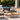 Poolside outdoor entertaining area with timber lounge furniture, grey cushions, coffee table and white sun lounges in a modern Australian backyard.